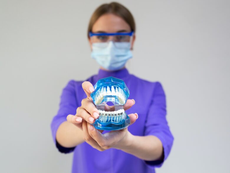 https://www.pexels.com/photo/woman-dentist-demonstrating-plastic-dental-cleaning-system-with-braces-7787980/